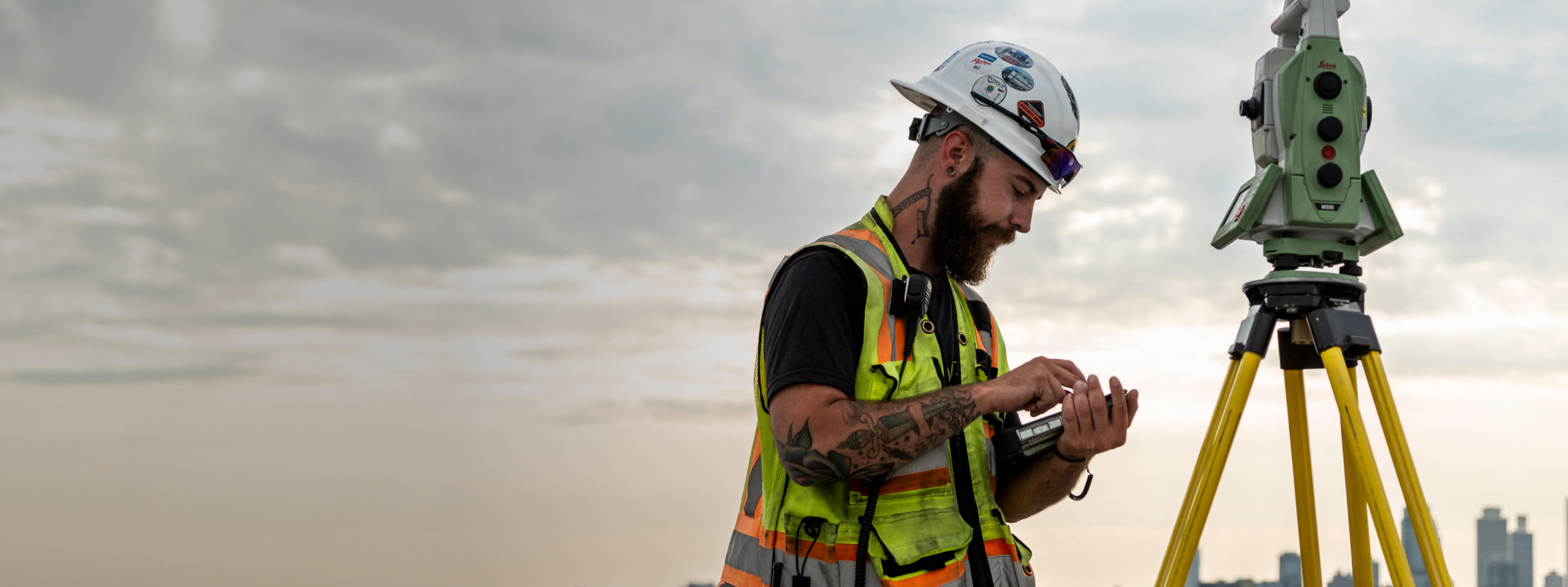 A construction worker using a theodolite