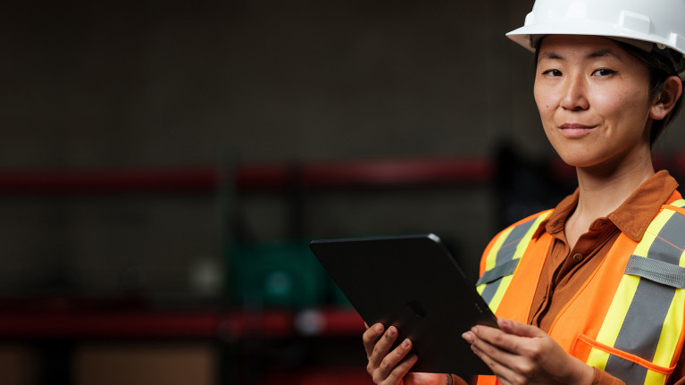 Woman holding a tablet and looking at the camera