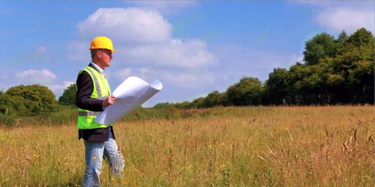 Photo of architect on future construction site during the predevelopment phase deciding on site feasibility