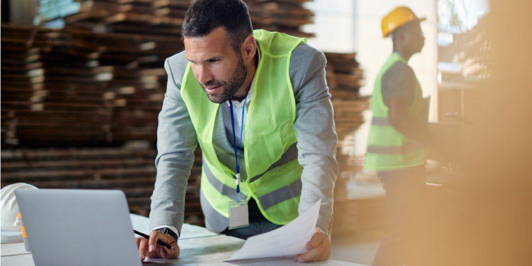 Contractor inspecting documents on a laptop